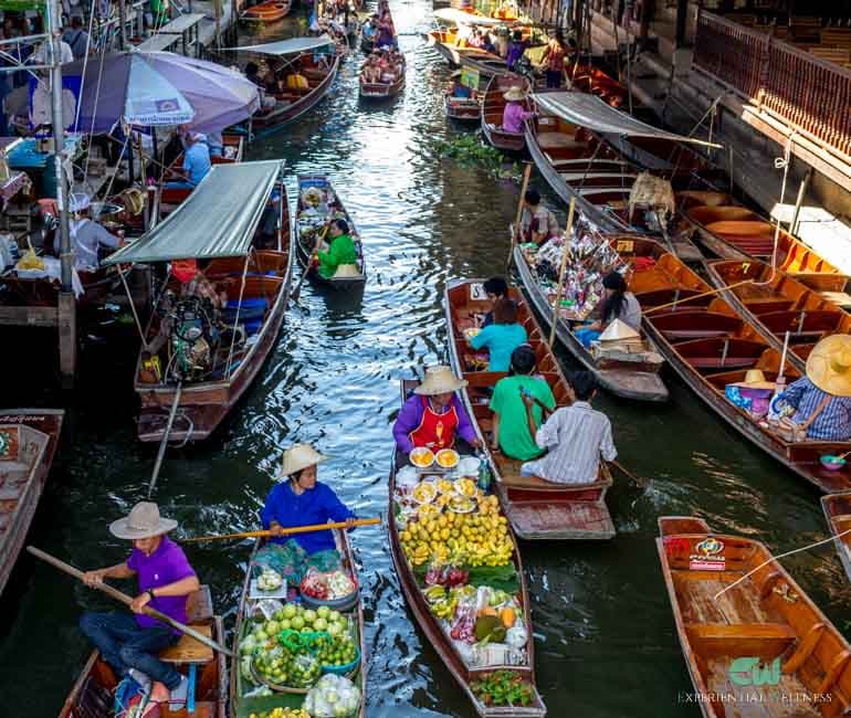 Thailändische Händler paddeln durch den Kanal von Damnoen Saduak