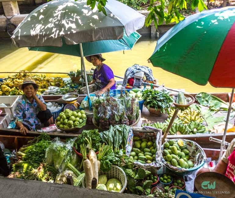 Reisende verhandeln mit einem lokalen Händler auf dem Lad Mayom Floating Market