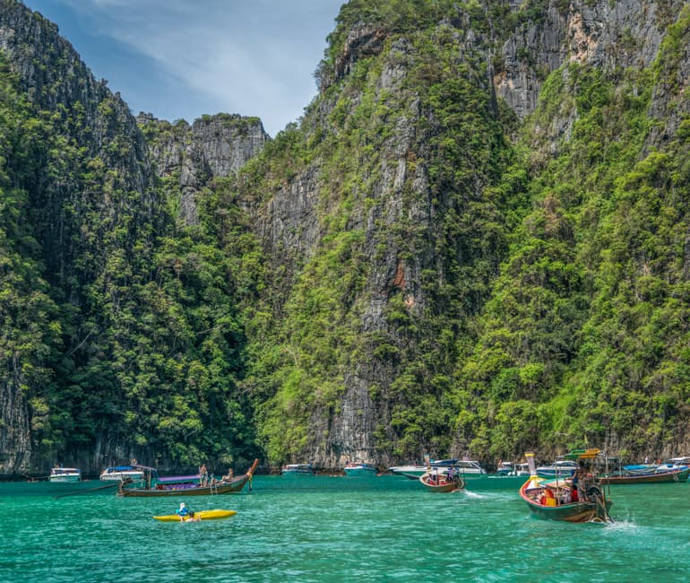 Petits bateaux se dirigeant vers un canyon calcaire à Krabi