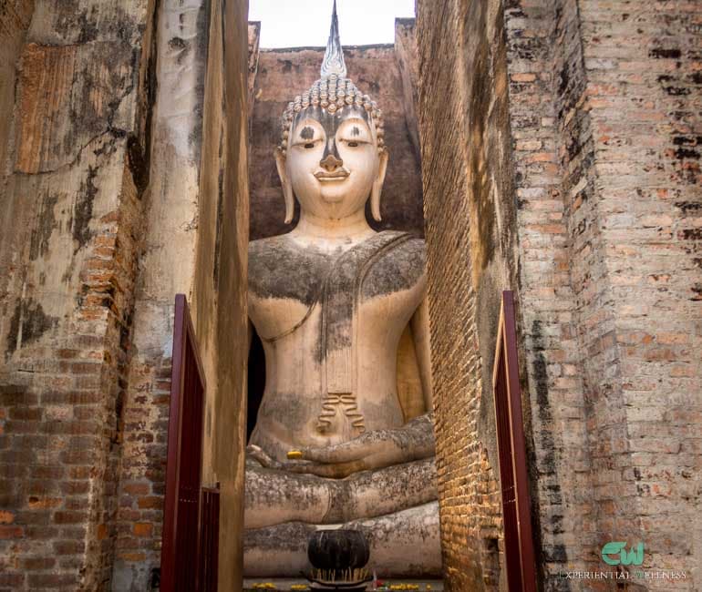 Sitzende Buddha-Darstellung in einem kleinen Backstein-Mandapa im Historischen Park Sukhothai