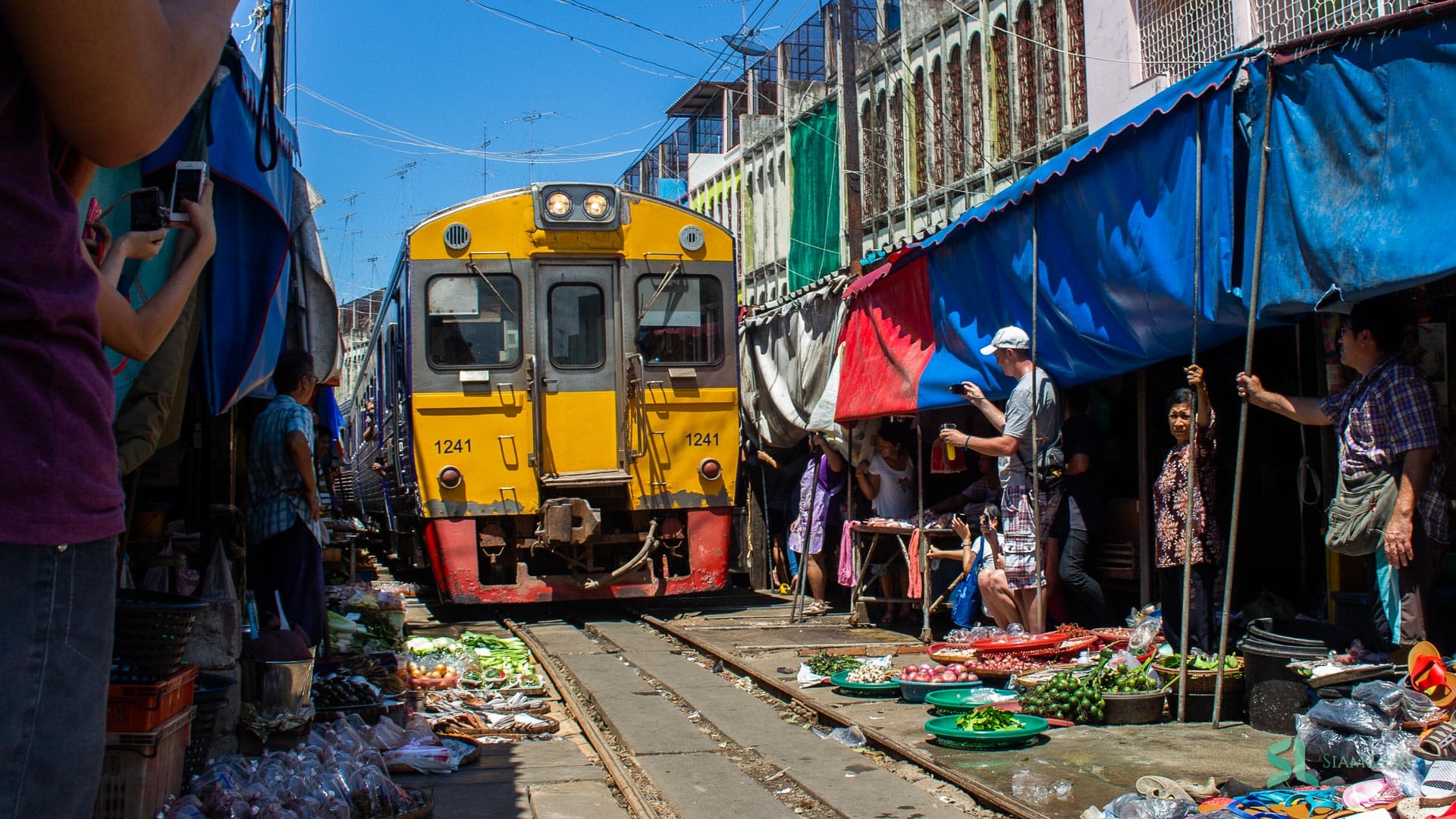 Un train approche du marché ferroviaire de Maeklong