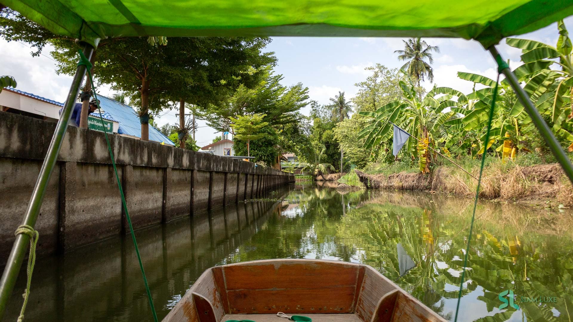 Longtail-Boot auf einem Kanal nahe einem schwimmenden Markt